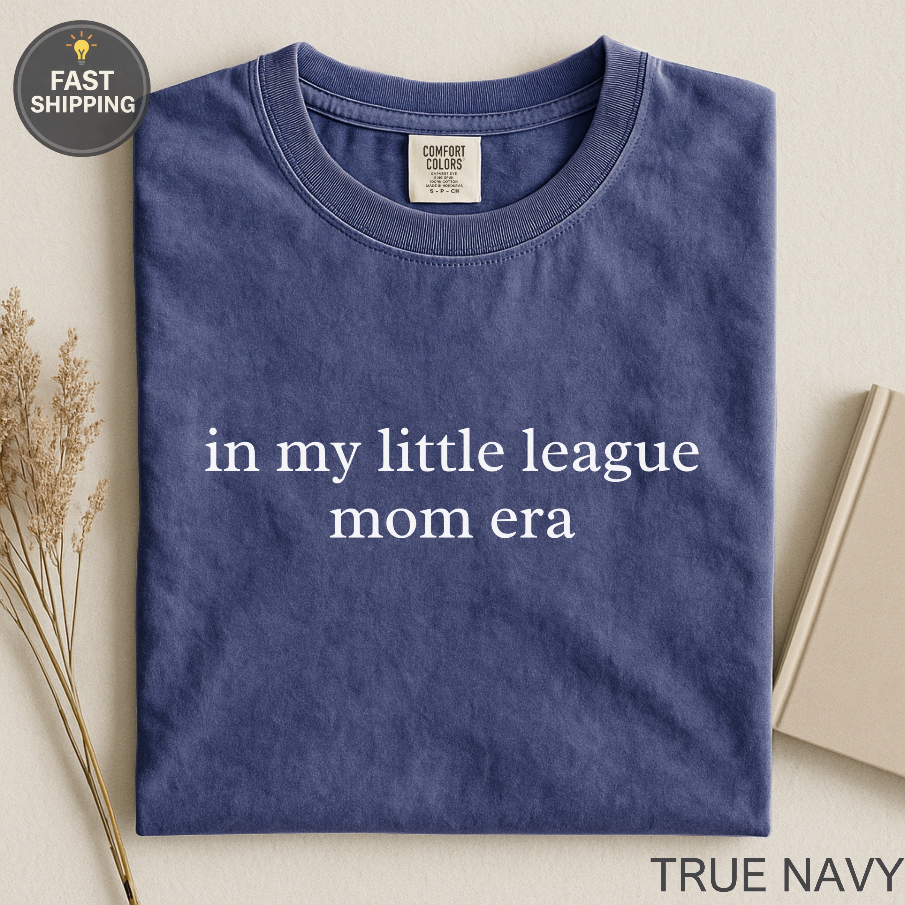 Navy t-shirt with "in my little league mom era" text.