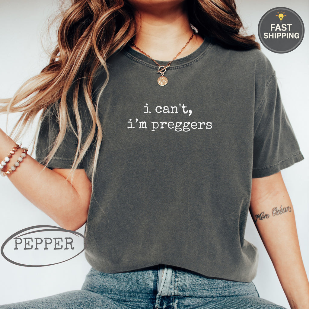 Woman wearing charcoal t-shirt with "i can't, i'm preggers" text.