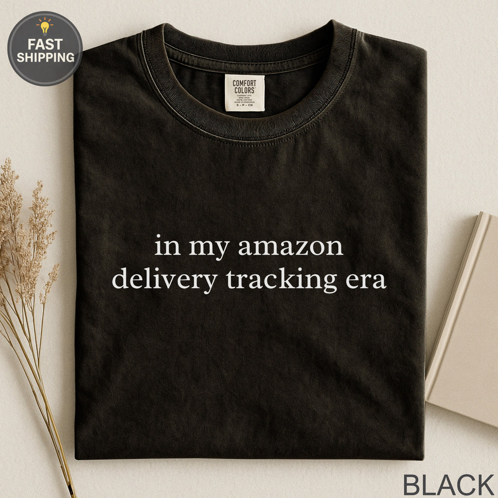 Black t-shirt with white text "in my amazon delivery tracking era".
