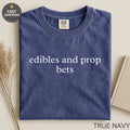 Navy t-shirt with "edibles and prop bets" printed in white.