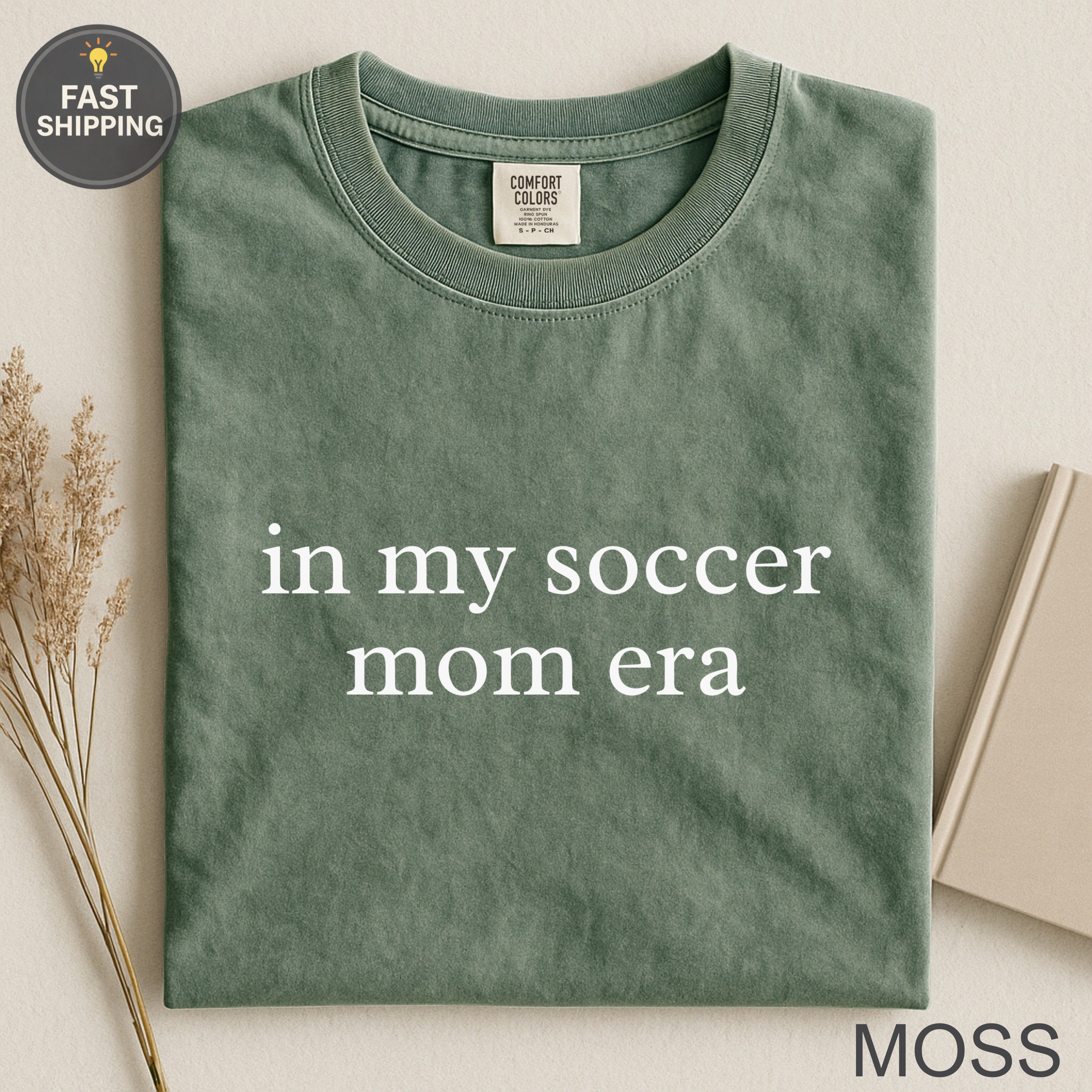Sage green t-shirt with "in my soccer mom era" text.