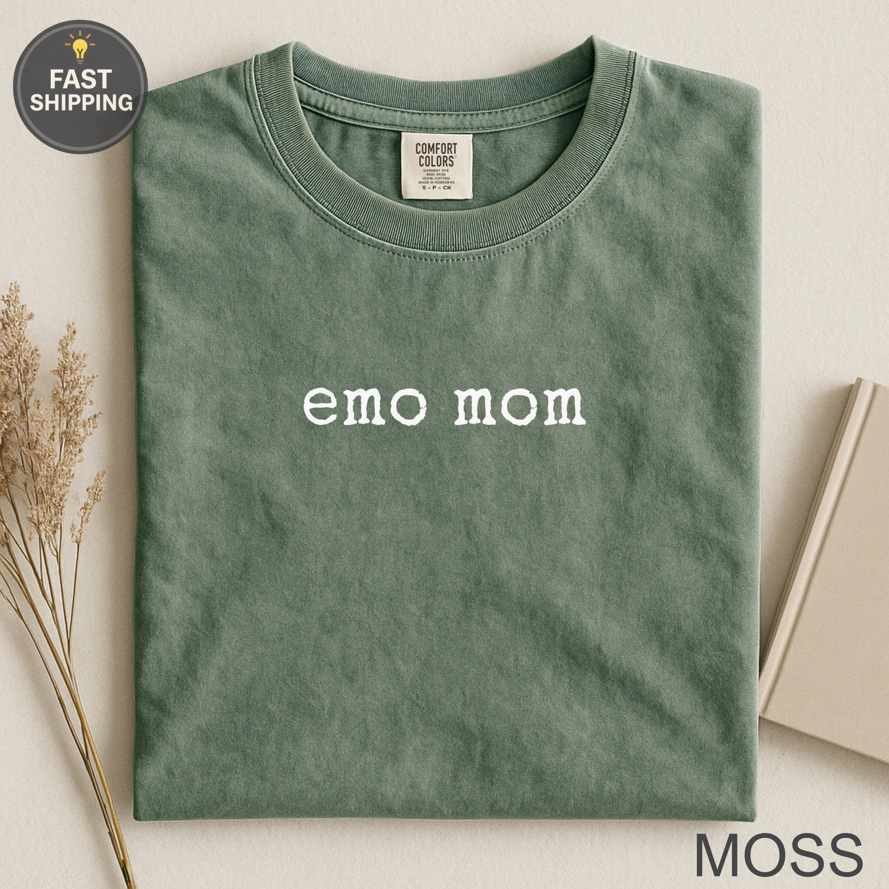 Green t-shirt with "emo mom" printed in white, "Moss" at bottom right.