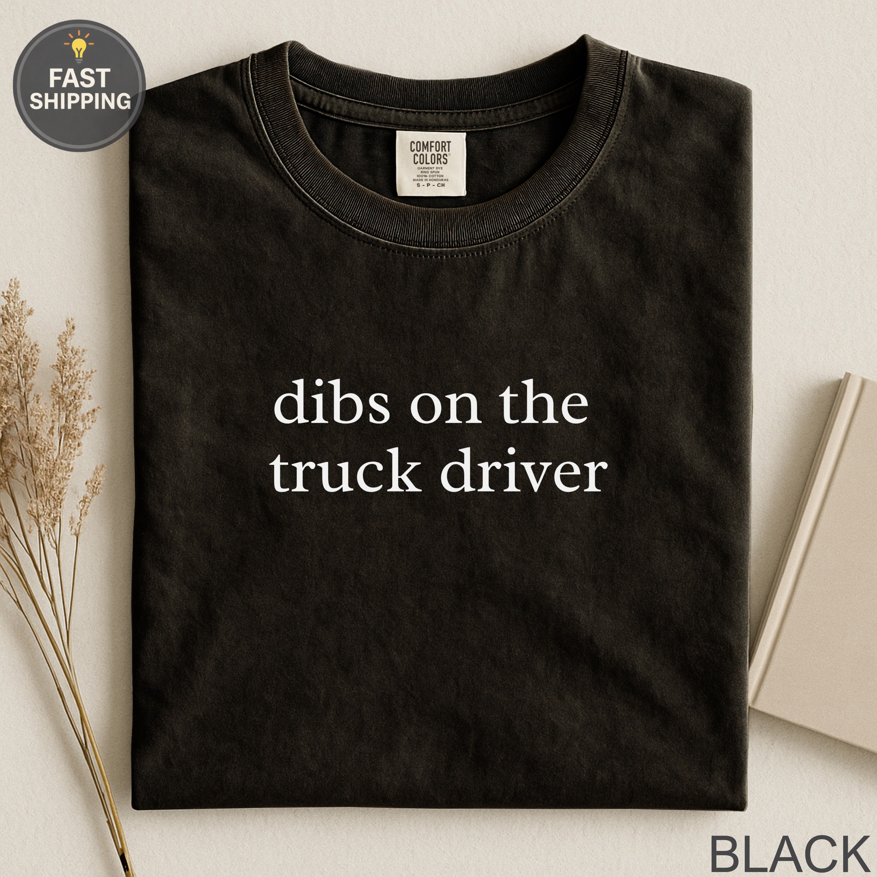 Black Comfort Colors t-shirt with "dibs on the truck driver" text.