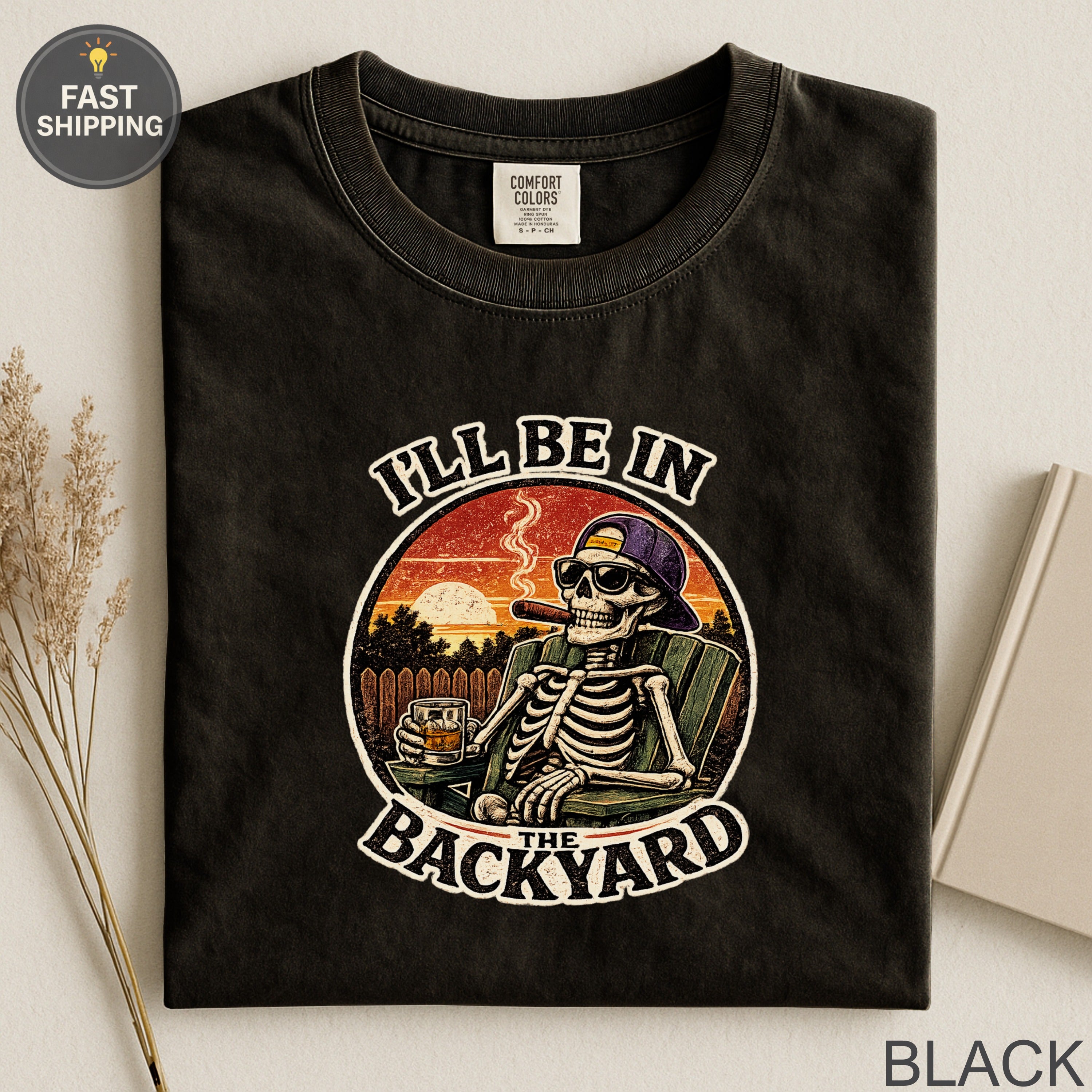 Skeleton wearing sunglasses and smoking cigar in chair, "I'll Be In The Backyard" text.