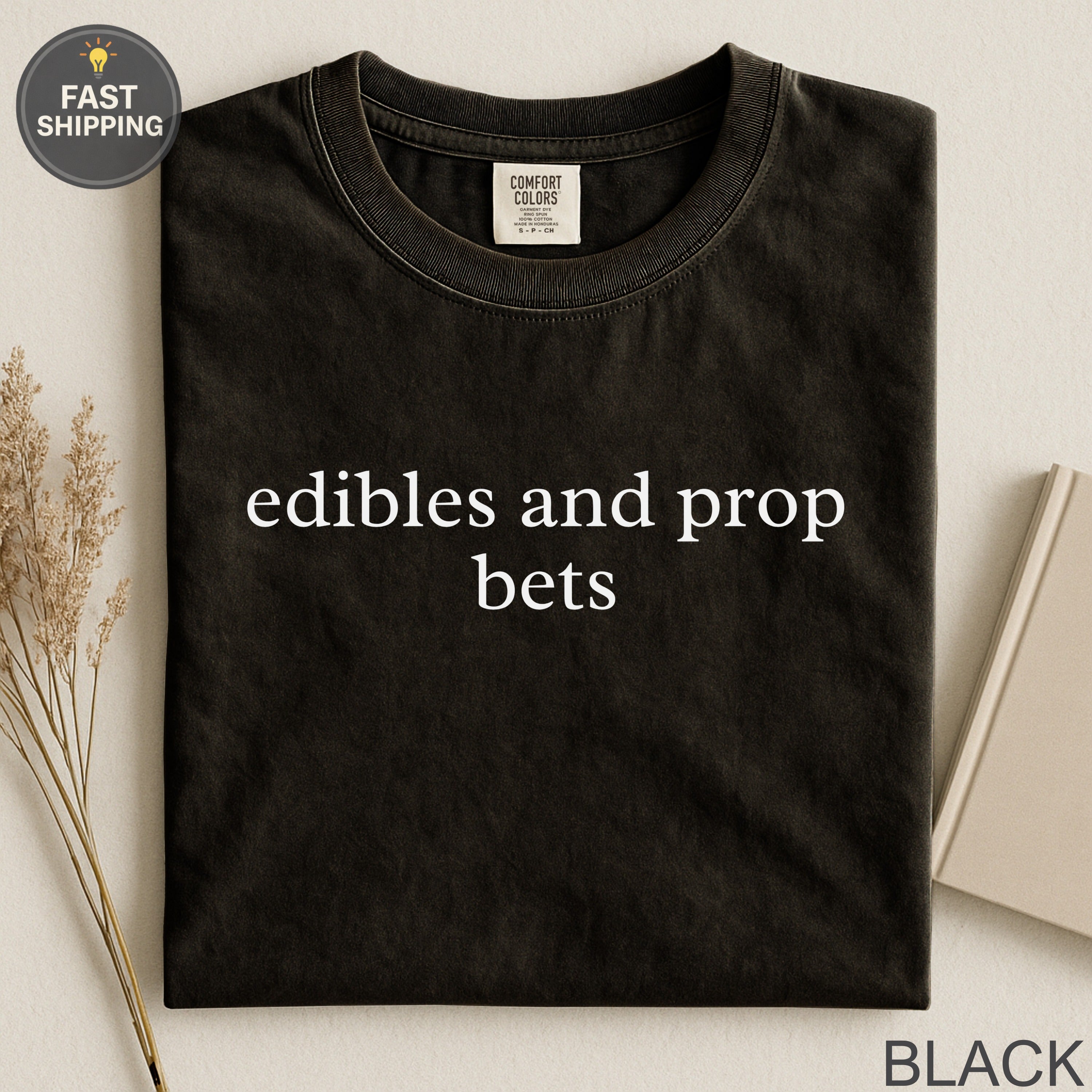 Black Comfort Colors t-shirt with "edibles and prop bets" printed in white.