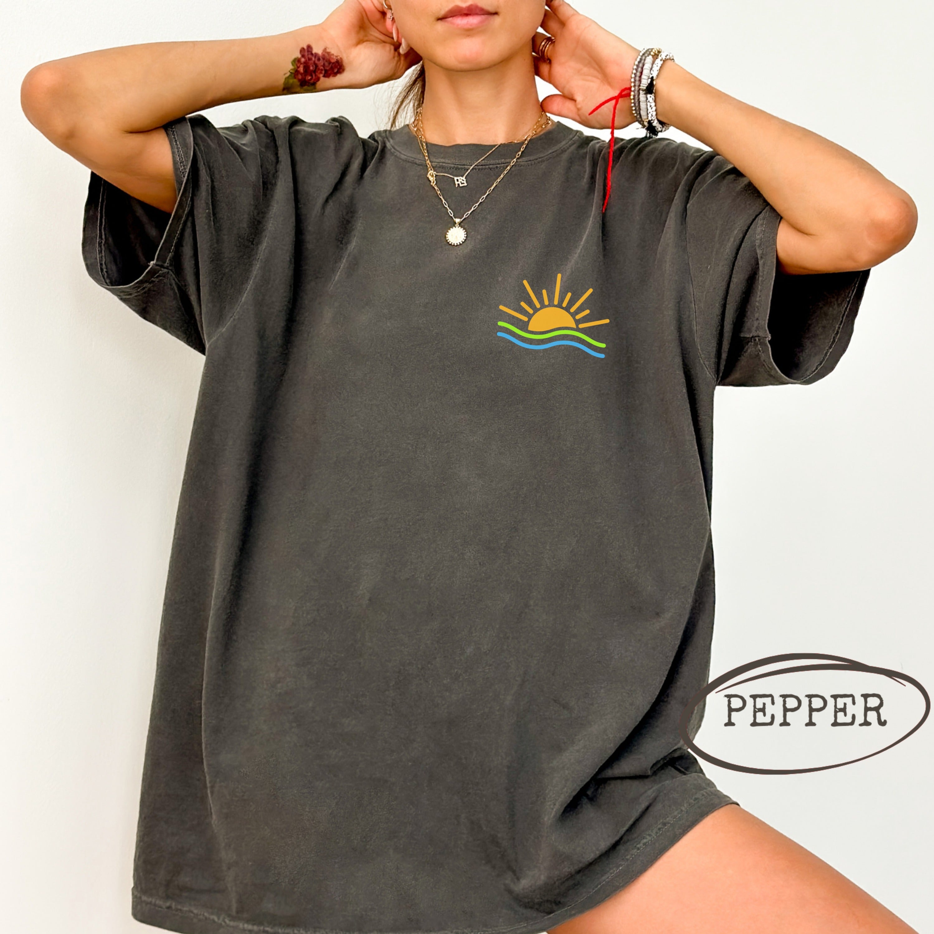 Dark gray t-shirt with a sunset graphic and "PEPPER" text.