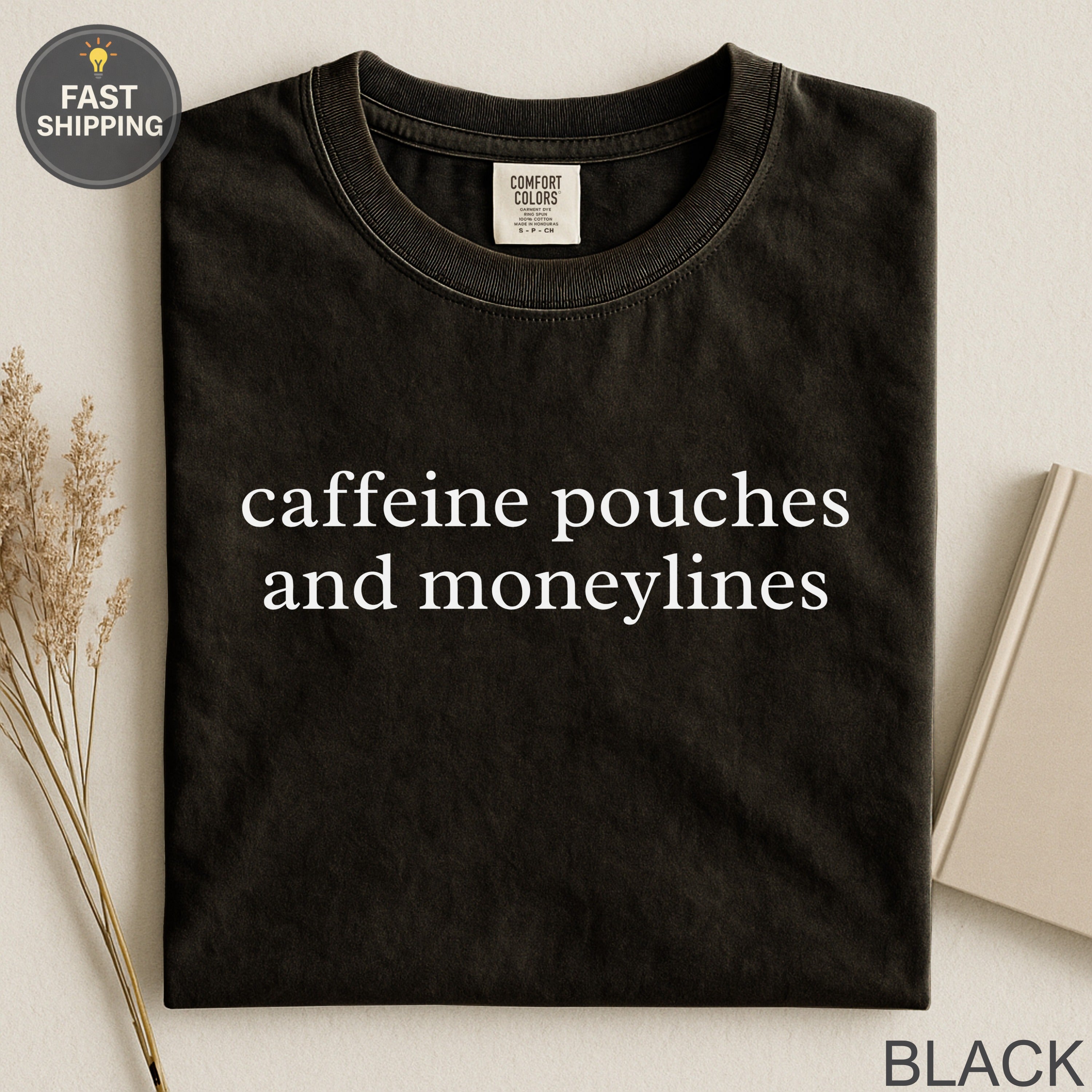 Black t-shirt with "caffeine pouches and moneylines" text.