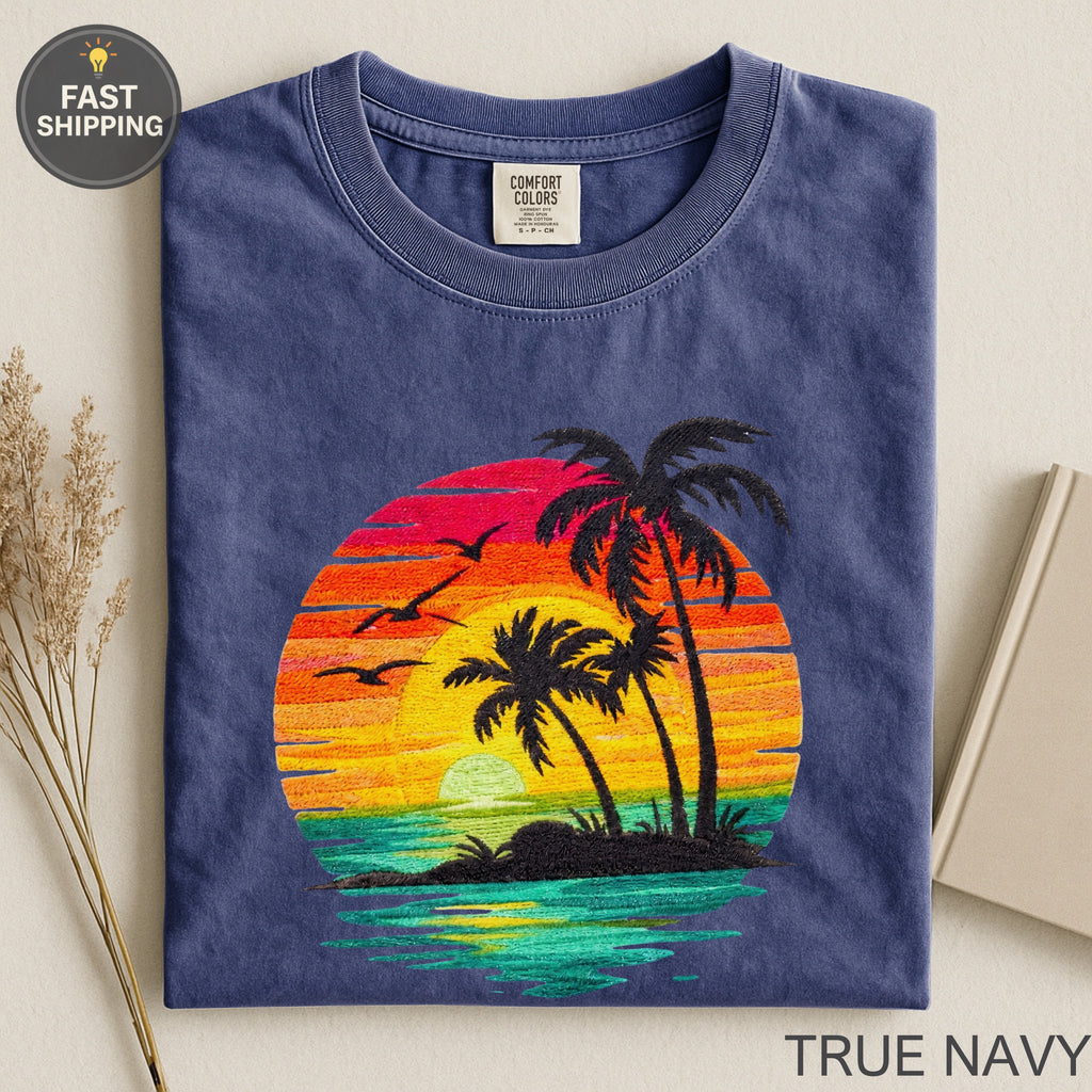 Navy t-shirt with embroidered sunset, palm trees, and birds.