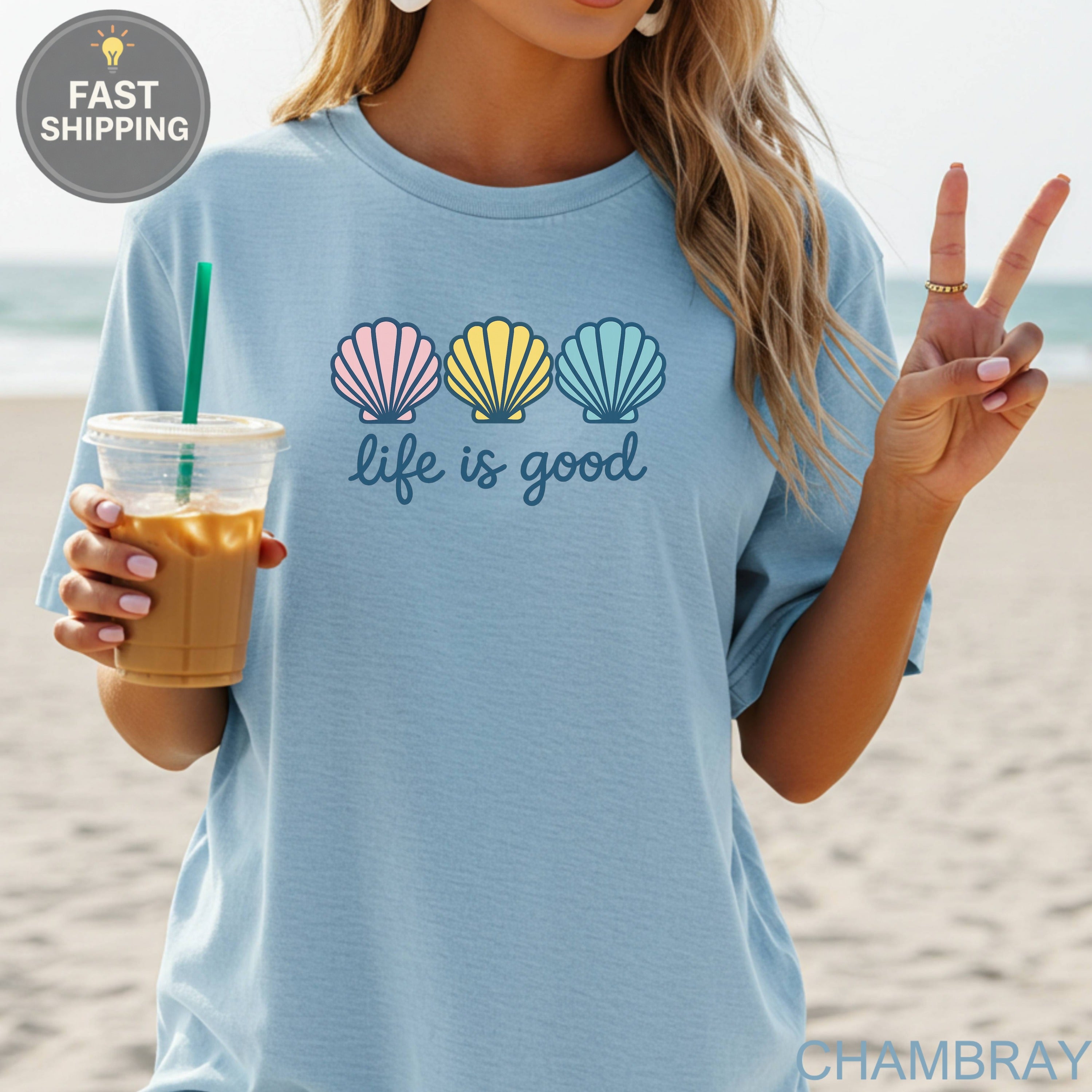 Light blue t-shirt with three colorful seashells and "life is good" text.