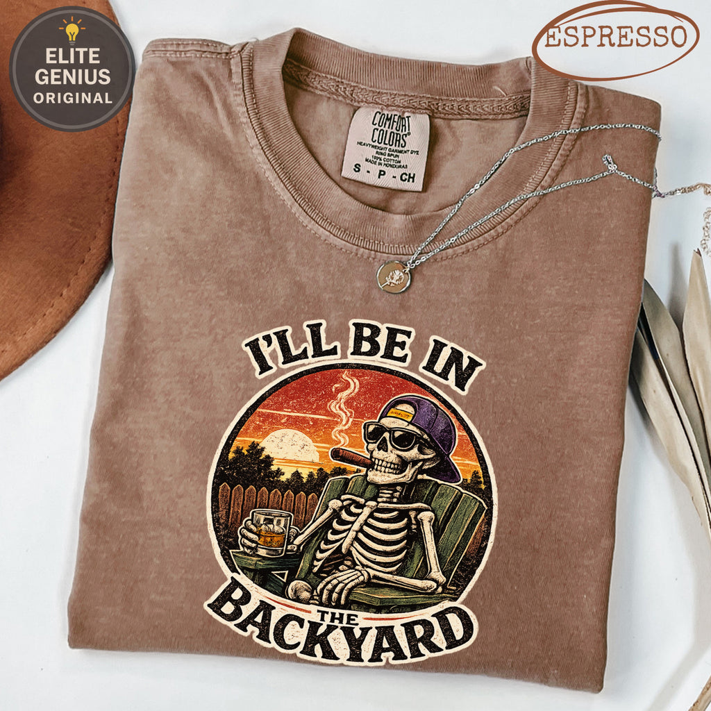 Skeleton smoking cigar in lounge chair with "I'LL BE IN THE BACKYARD" text.