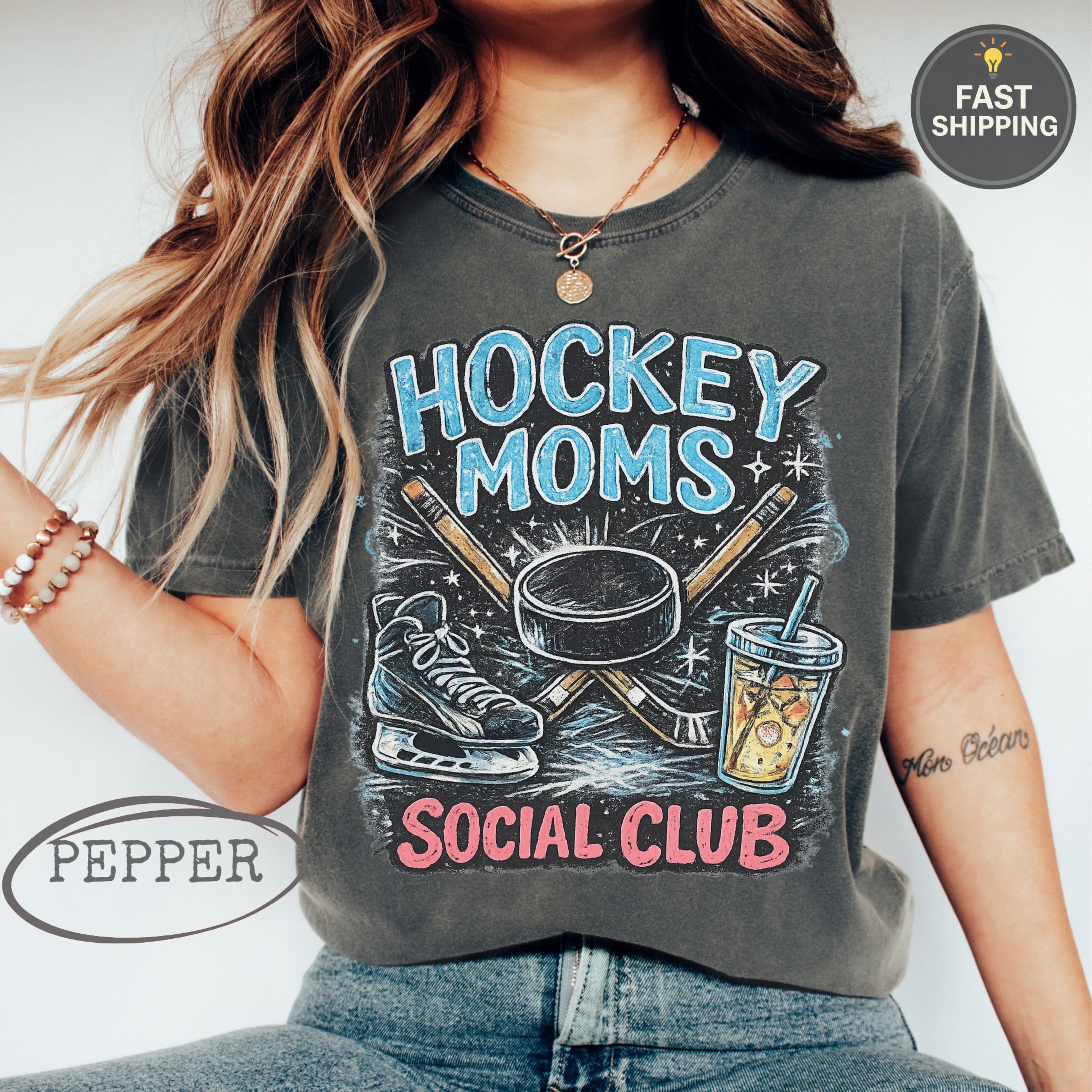 T-shirt with "Hockey Moms Social Club" text, hockey sticks, puck, and ice skate.