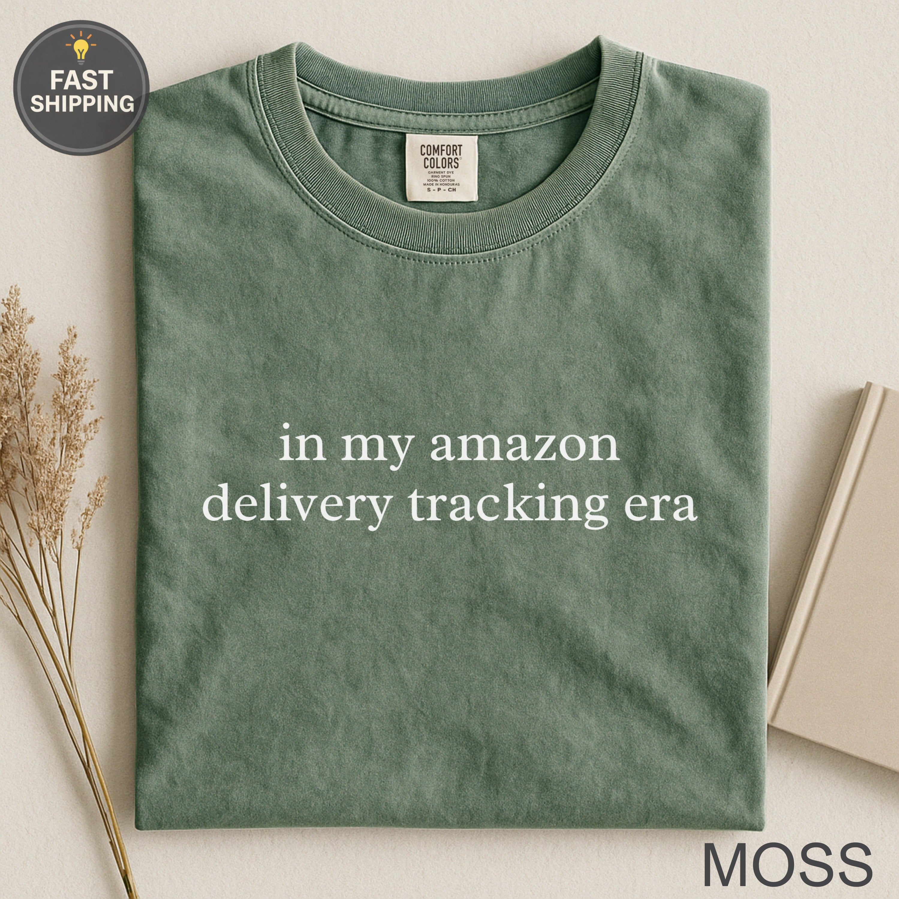 Green t-shirt with "in my amazon delivery tracking era" text.