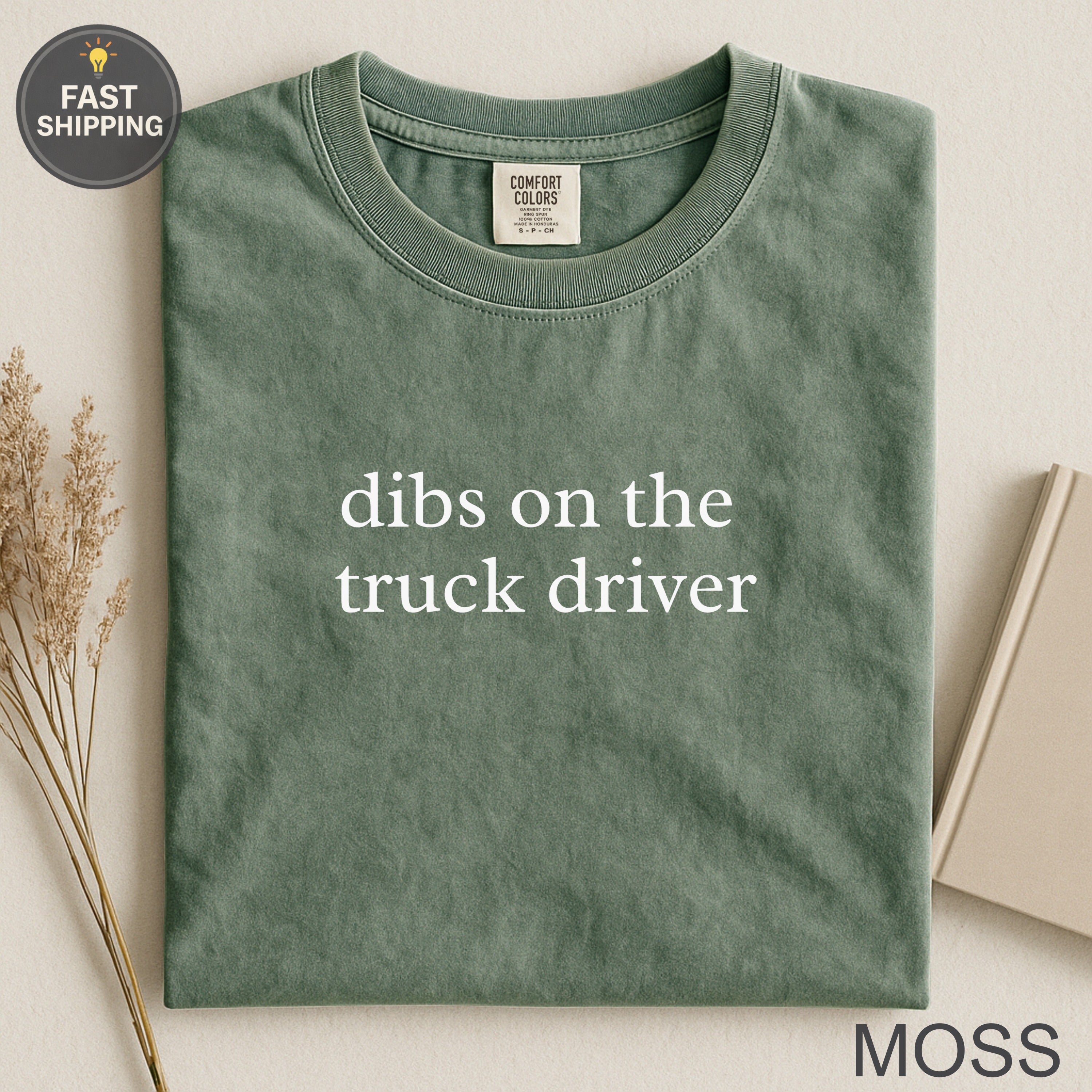 Green t-shirt with "dibs on the truck driver" printed in white.