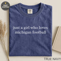 Navy t-shirt with "just a girl who loves michigan football" text.