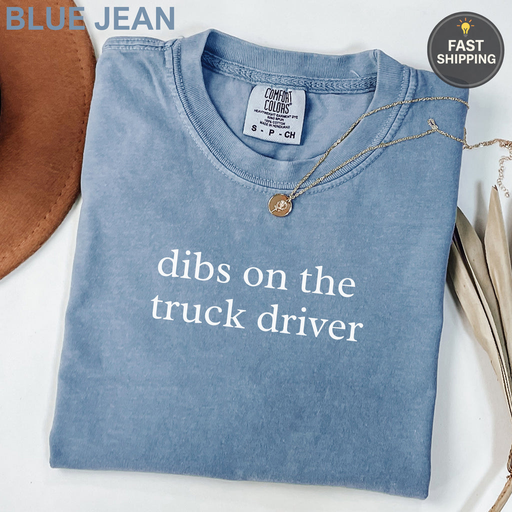 Blue t-shirt with "dibs on the truck driver" text and a small necklace.